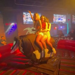 3 girls riding a bull together